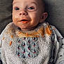 baby, bib, food, messy, orange_food, face, infant, clothing, cute, expression, eyes, mouth, texture, fabric, pattern, sitting, portrait, indoor, feeding, child