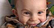 Malo Chambre participe au concours pour gagner de l'argent avec cette photo : animal_pattern, baby, buttoned_clothing, cheeky_grin, child, closeup, colorful_background, cozy, cute, eyes, face, happy, indoor, infant, plaid_jacket, playful, portrait, smile, warm_clothing, young_child
