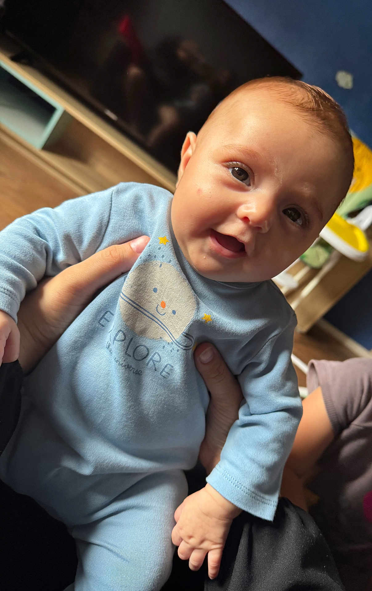 Neyla participe au concours pour gagner de l'argent avec cette photo : baby, child, smiling, blue_outfit, indoor, person, hand, face, cute, happy, infant, clothing, sitting, home, furniture, television, floor, skin, portrait, young