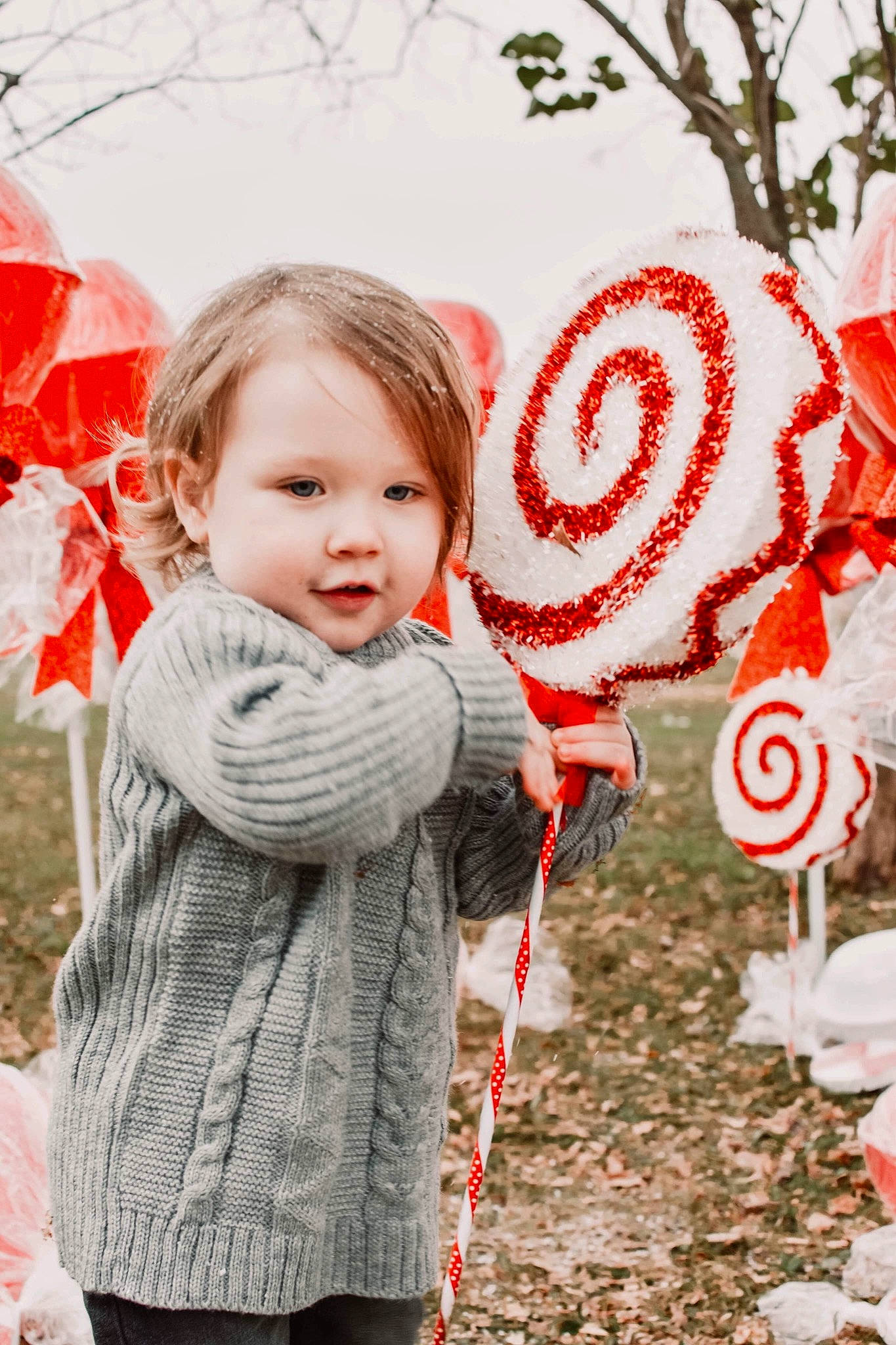 Foster is registered to the contest to win money with this photo: baby_toddler_clothing, child, facial_expression, fun, grass, happy, leaf, lip, orange, pattern, people_in_nature, person, photograph, pink, plant, red, textile, toddler, tree, white