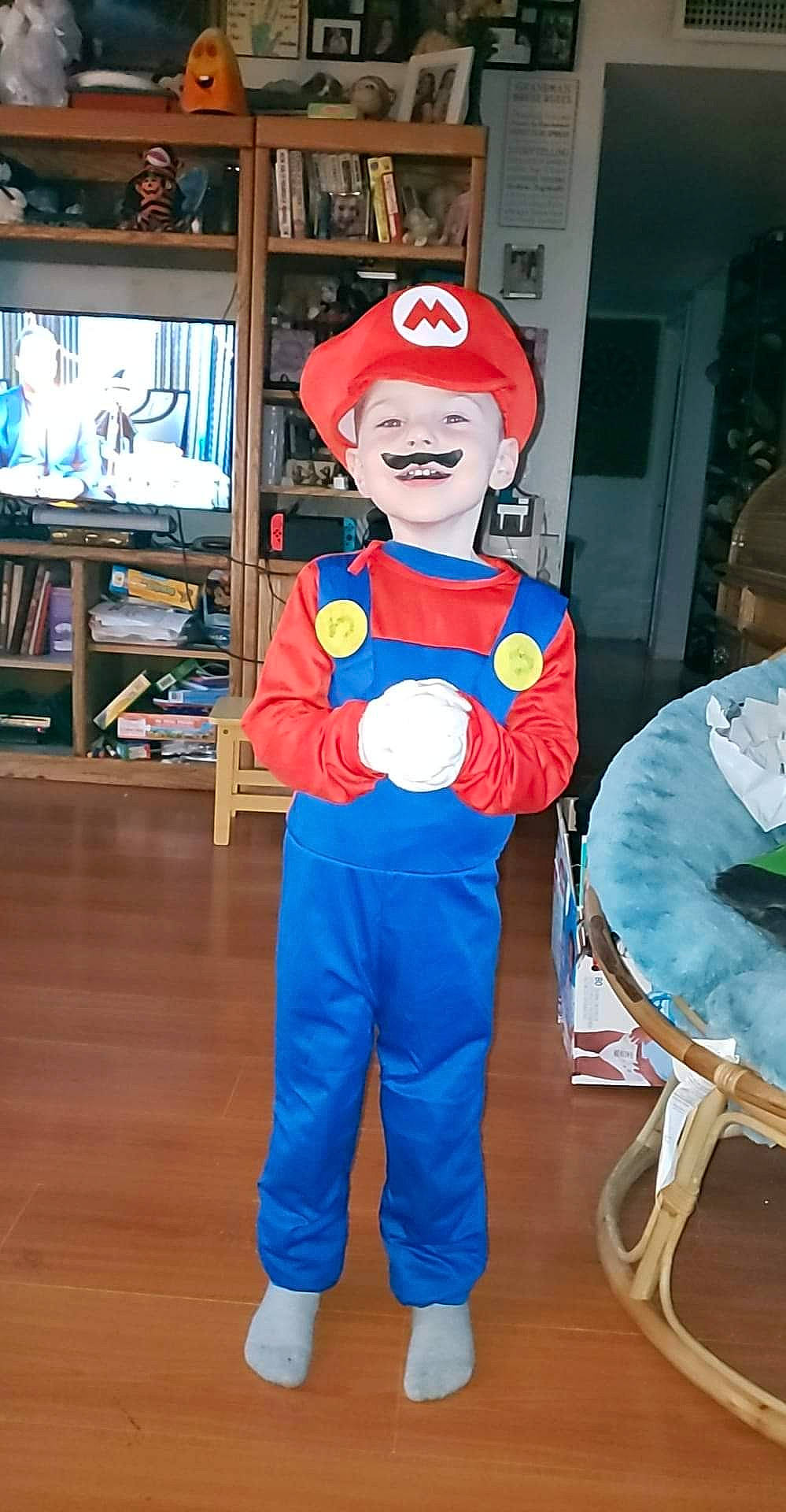 Dustin joined the competition — help win amazing prizes! chair, costume, costume_hat, electric_blue, event, fictional_character, flooring, fun, hardwood, hat, headgear, mario, mascot, person, personal_protective_equipment, room, shelf, smile, t_shirt, television