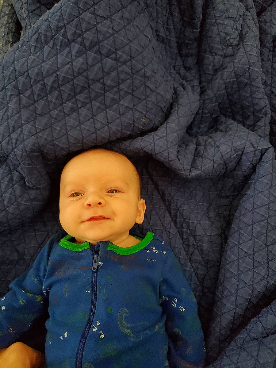 Daxton joined the competition — help win amazing prizes! baby, baby_toddler_clothing, cheek, child, electric_blue, fun, grass, happy, nose, outerwear, person, portrait_photography, recreation, rock, sitting, skin, sleeve, smile, t_shirt, toddler