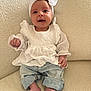 Ayana is registered to the contest to win money with this photo: baby, infant, child, white_bow, headband, white_blouse, denim_pants, barefoot, couch, textured_fabric, indoor, portrait, cute, smiling, seated, young_child, cozy, light_skin, happy, small_hands