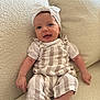 baby, infant, smile, headband, bow, striped_clothing, romper, white_shirt, couch, soft_texture, indoor, happy, child, person, cute, sitting, small_hands, small_feet, comfortable, cozy