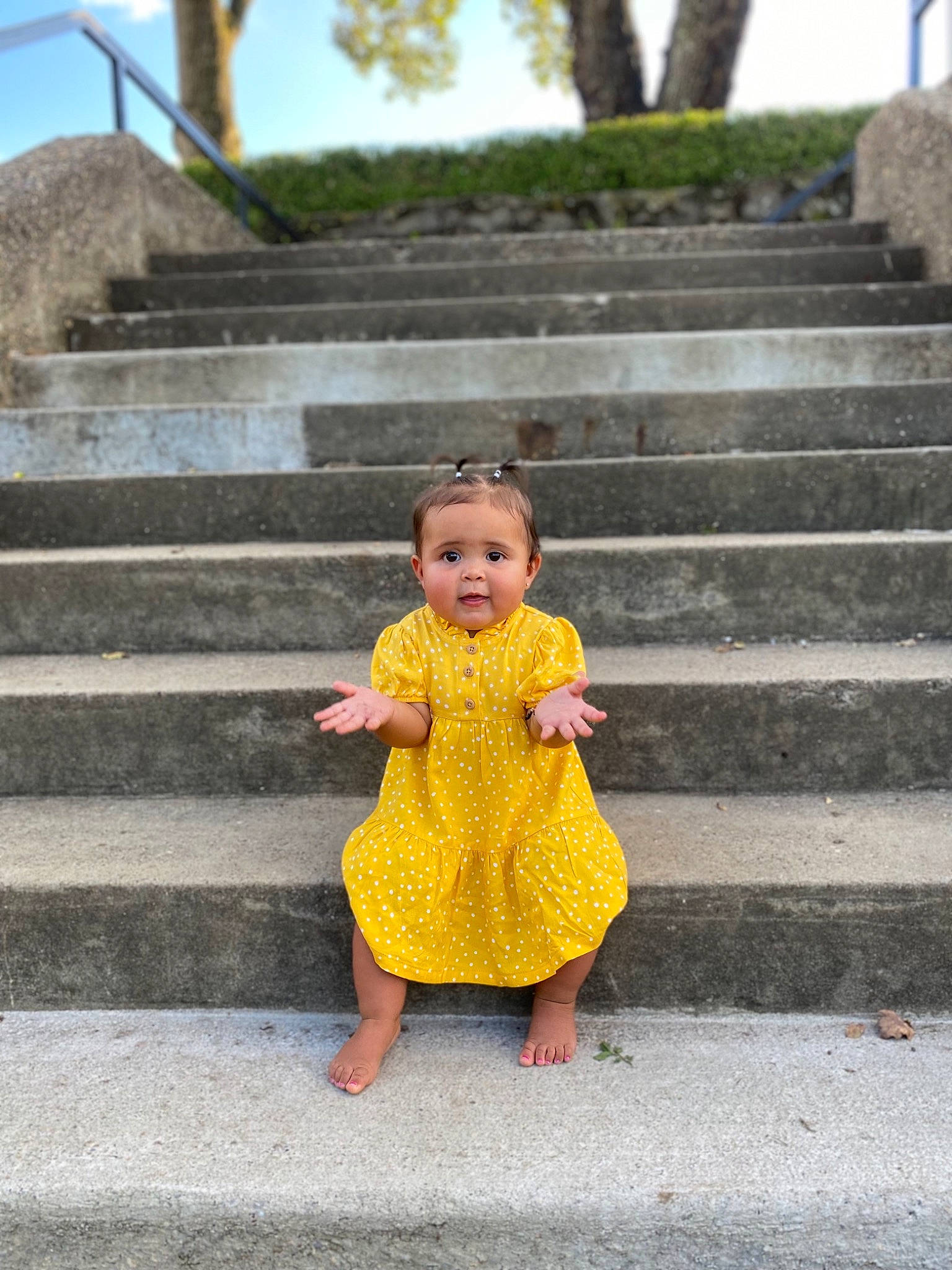 Vivianna is registered to the contest to win money with this photo: baby, baby_toddler_clothing, child, dress, grass, hair, happy, leaf, leisure, people_in_nature, person, photograph, plant, sky, smile, stairs, temple, toddler, tree, wall