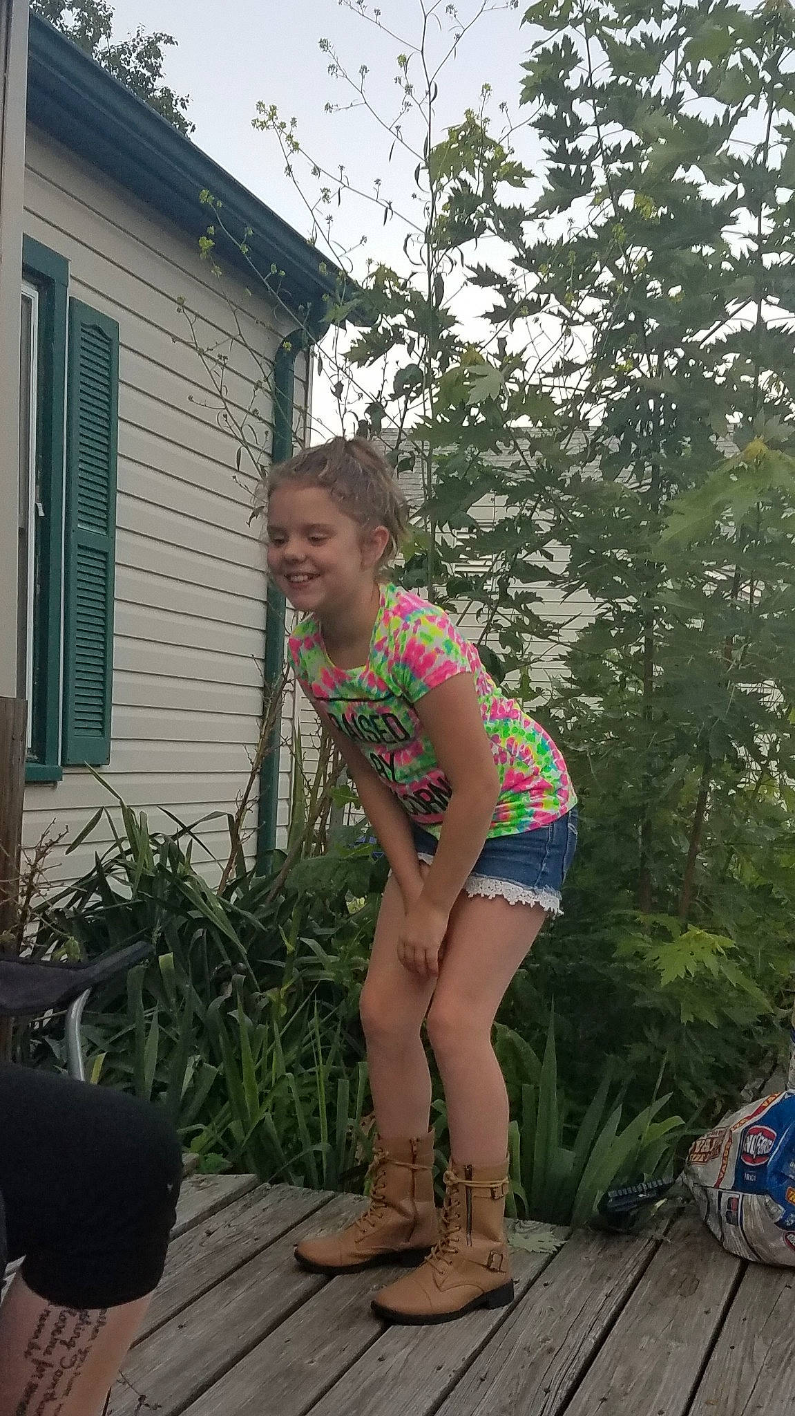 Lahela is registered to the contest to win money with this photo: backyard, fun, garden, girl, grass, green, house, human_body, joy, leg, muscle, outdoor_structure, person, plant, shorts, standing, summer, tree, trunk, vacation