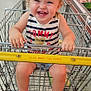 Rayne joined the competition — help win amazing prizes! toddler, shopping_cart, grocery_store, smiling, child, curly_hair, striped_shirt, denim_shorts, colorful_shoes, pink_socks, food_display, aisle, metal_cart, happy, indoor, retail, person, casual_clothing, cute, playful