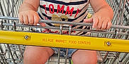 Rayne is registered to the contest to win money with this photo: toddler, child, shopping_cart, smile, happy, curly_hair, clothing, shoes, socks, grocery_store, aisle, metal, floor, person, retail, store, shopping, baby, young_child, cute