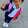 Miss Naomi is registered to the contest to win money with this photo: child, girl, pigtails, beads, peace_sign, jacket, backpack, white_shoes, pavement, outdoor, smile, standing, casual_clothing, young, person, fashion, cute, happy, portrait, daylight
