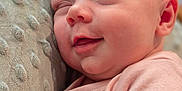Teagan is registered to the contest to win money with this photo: baby, child, closeup, comfort, cushion, cute, face, hand, indoors, infant, newborn, peaceful, pink_clothing, portrait, relaxation, skin, sleeping, smile, soft, texture