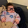 baby, sleeping, glasses, onesie, cartoon_characters, blanket, couch, child, indoors, cozy, hands, face, hair, soft, resting, peaceful, cute, portrait, relaxed, home