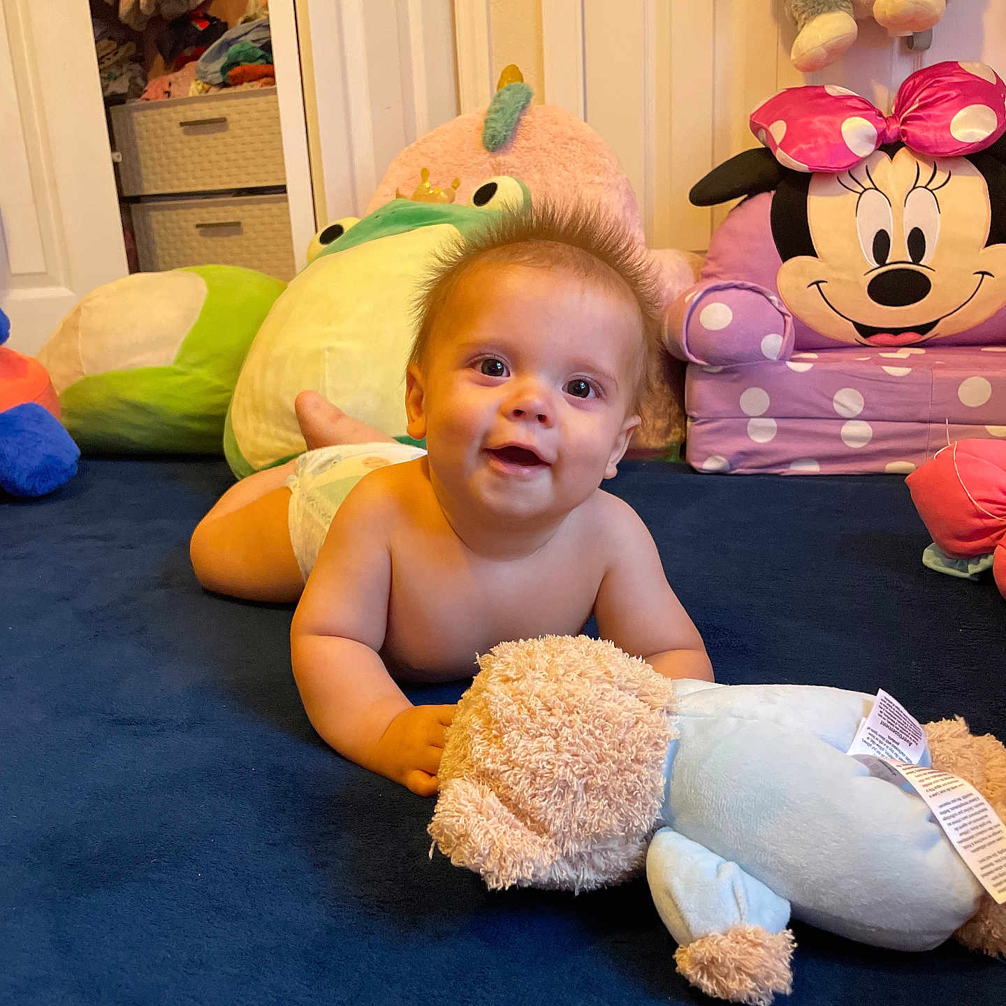 Jameson is registered to the contest to win money with this photo: baby, carpet, child, closet, colorful, crawling, cute, diaper, door, furniture, happy, indoor, infant, mickey_mouse, plush_toy, room, smiling, stuffed_animal, teddy_bear, toy