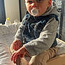 Tiago participe au concours pour gagner de l'argent avec cette photo : baby, pacifier, denim_vest, grey_sleeves, beige_pants, sock, hand, face, indoor, wooden_furniture, changing_table, sunlight, window, child, sitting, clothing, cute, infant, person, closeup