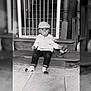 Tiago a rejoint le concours — aidez-le/la à gagner de superbes lots ! toddler, child, baby, pacifier, cap, bottle, stairs, baby_gate, socks, jeans, jacket, wood, floor, tile_floor, indoor, portrait, sitting, curious, monochrome, household