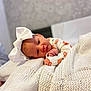 Delilah is registered to the contest to win money with this photo: baby, infant, white_bow, knitted_blanket, cozy, sleepy, cute, newborn, soft_texture, wrapped, portrait, small_hands, laying_down, indoors, warm, patterned_clothing, head_accessory, close_up, peaceful, resting