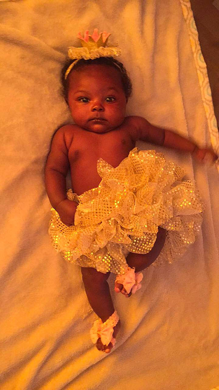 Nakiah is registered to the contest to win money with this photo: child, flower, fun, girl, hair_accessory, happiness, infant, person, smile, toddler, yellow