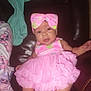 baby, infant, pink_dress, headband, sitting, leather_chair, clothing, blanket, cartoon_character, indoor, person, cute, child, apparel, furniture, portrait, soft_toys, colorful, young_child, comfortable