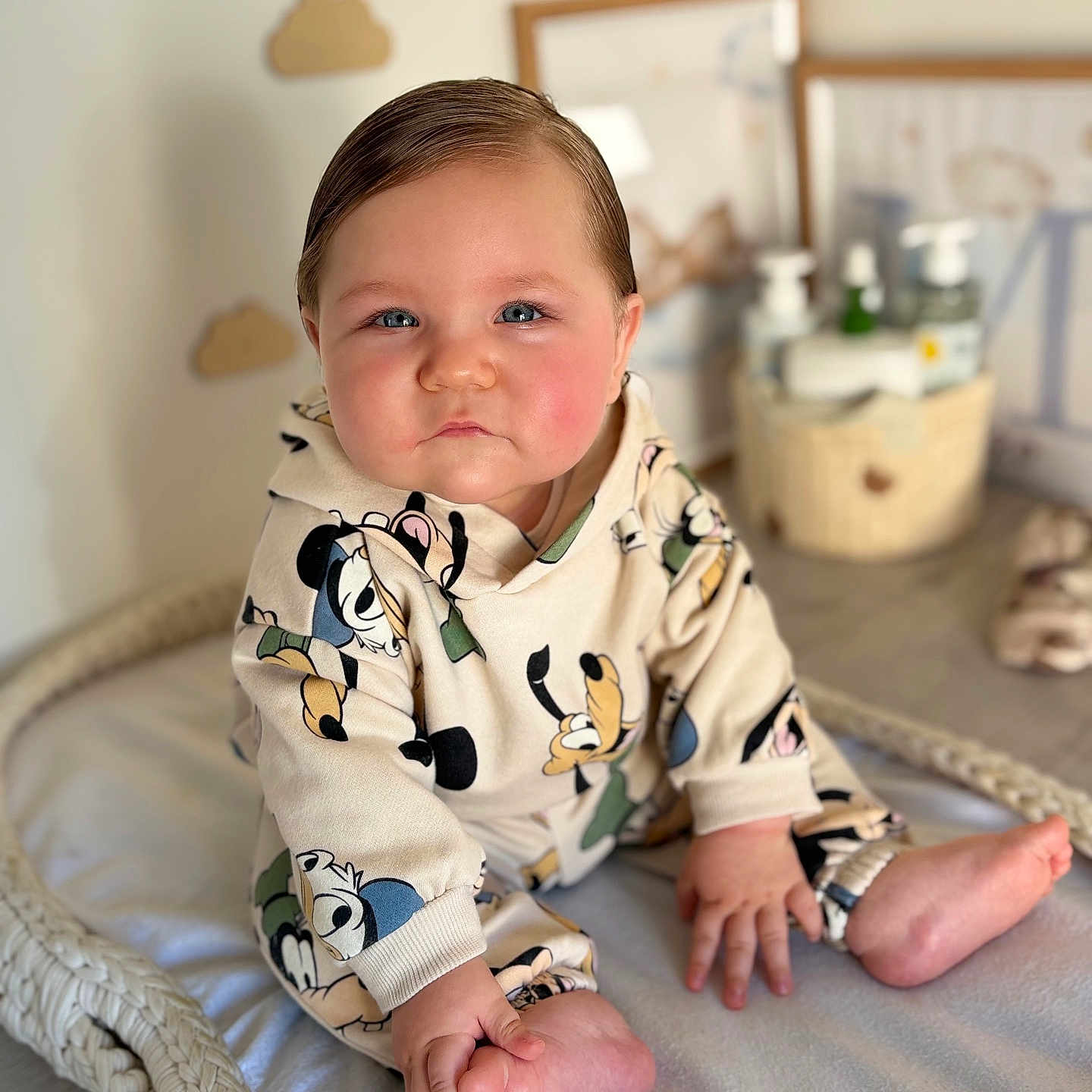 Menzo participe au concours pour gagner de l'argent avec cette photo : baby, basket, blanket, blue_eyes, cozy, cute, expression, hands, hoodie, infant, lotion_bottles, mickey_mouse_print, nursery, plush, portrait, rosy_cheeks, sitting, toddler, toes, wood_floor