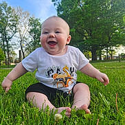 Ezra Ray is registered to the contest to win money with this photo: baby, blue_sky, child, cute, daytime, footwear_free, grass, greenery, happy, infant, nature, outdoor, park, playful, sitting, smiling, summer, sunlight, trees, tshirt