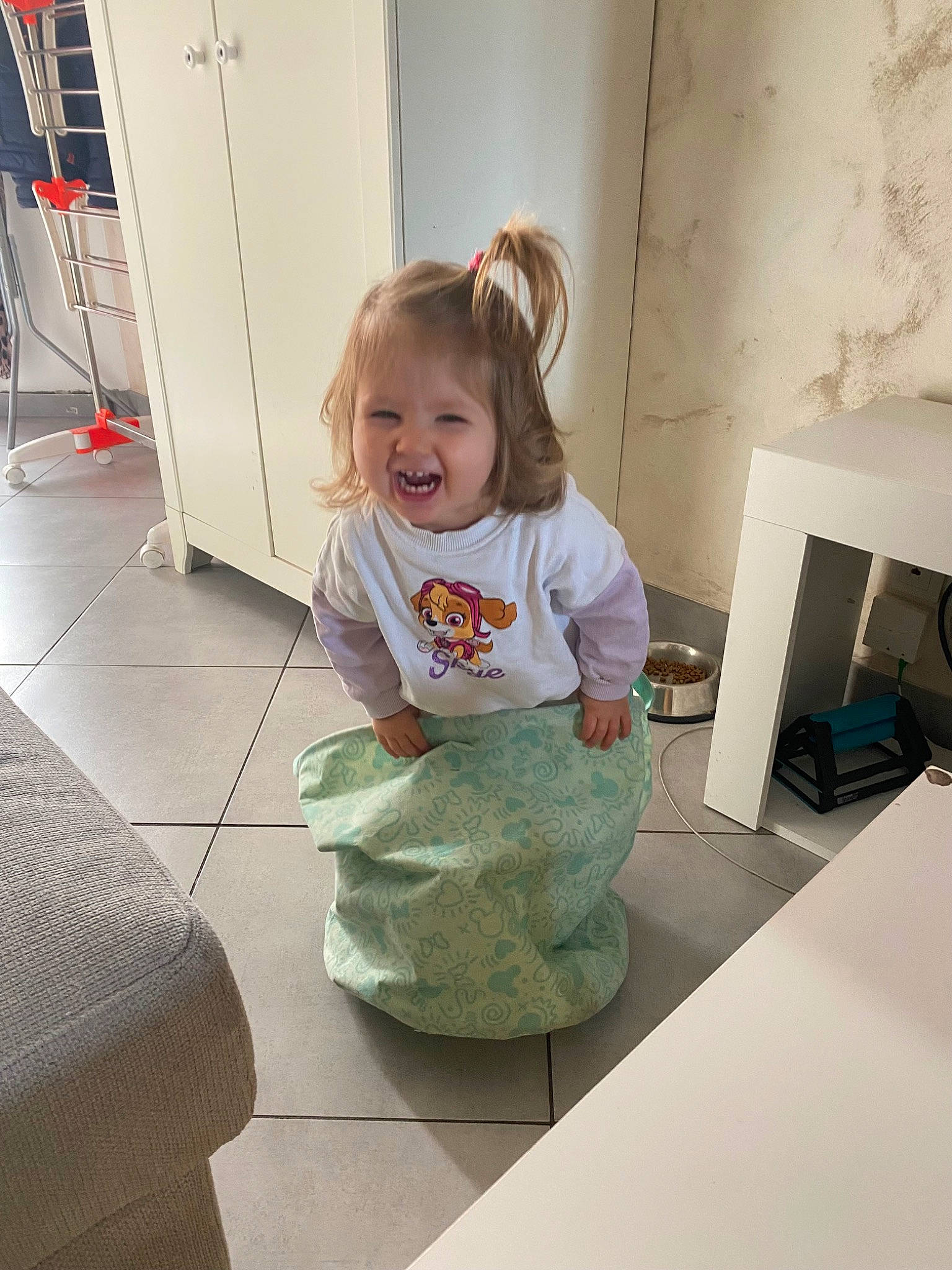 Louise participe au concours pour gagner de l'argent avec cette photo : baby, baby_toddler_clothing, child, cleanliness, comfort, floor, flooring, foot, fun, hardwood, human_leg, knee, person, play, room, sitting, smile, standing, t_shirt, toddler