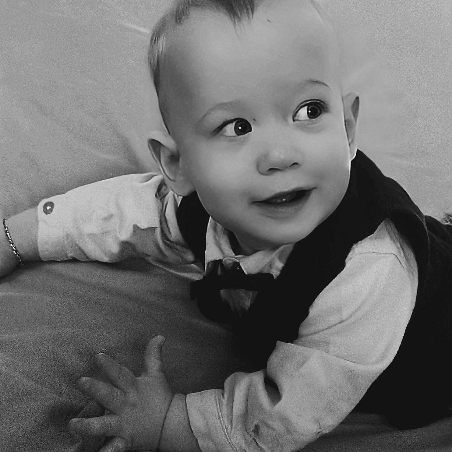 Nattan a rejoint le concours — aidez-le/la à gagner de superbes lots ! baby, black_and_white, child, clothing, curious, cute, face, hands, happy, indoor, infant, looking_away, lying_down, person, portrait, shirt, smiling, soft_surface, vest, young