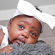 Kymori joined the competition — help win amazing prizes! baby, infant, face, headband, bow, eyes, skin, hand, texture, fluffy, closeup, portrait, cute, adorable, soft_lighting, indoor, child, expression, resting, curly_hair