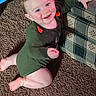 baby, child, smiling, happy, portrait, indoor, carpet, couch, seated, green_outfit, rosy_cheeks, blue_eyes, infant, playful, home, furniture, carpeted_floor, long_sleeves, photograph, cute