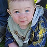 Carter joined the competition — help win amazing prizes! baby, child, infant, portrait, outdoor, grass, smiling, blue_eyes, plaid_shirt, bib, seated, hands, face, head, short_hair, sunlight, lawn, park, cute, photography