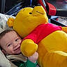 Carter joined the competition — help win amazing prizes! baby, child, infant, smiling, face, portrait, plush_toy, teddy_bear, winnie_the_pooh, yellow, red_shirt, cuddling, sitting, car_seat, vehicle, travel, indoor, happy, toy, family