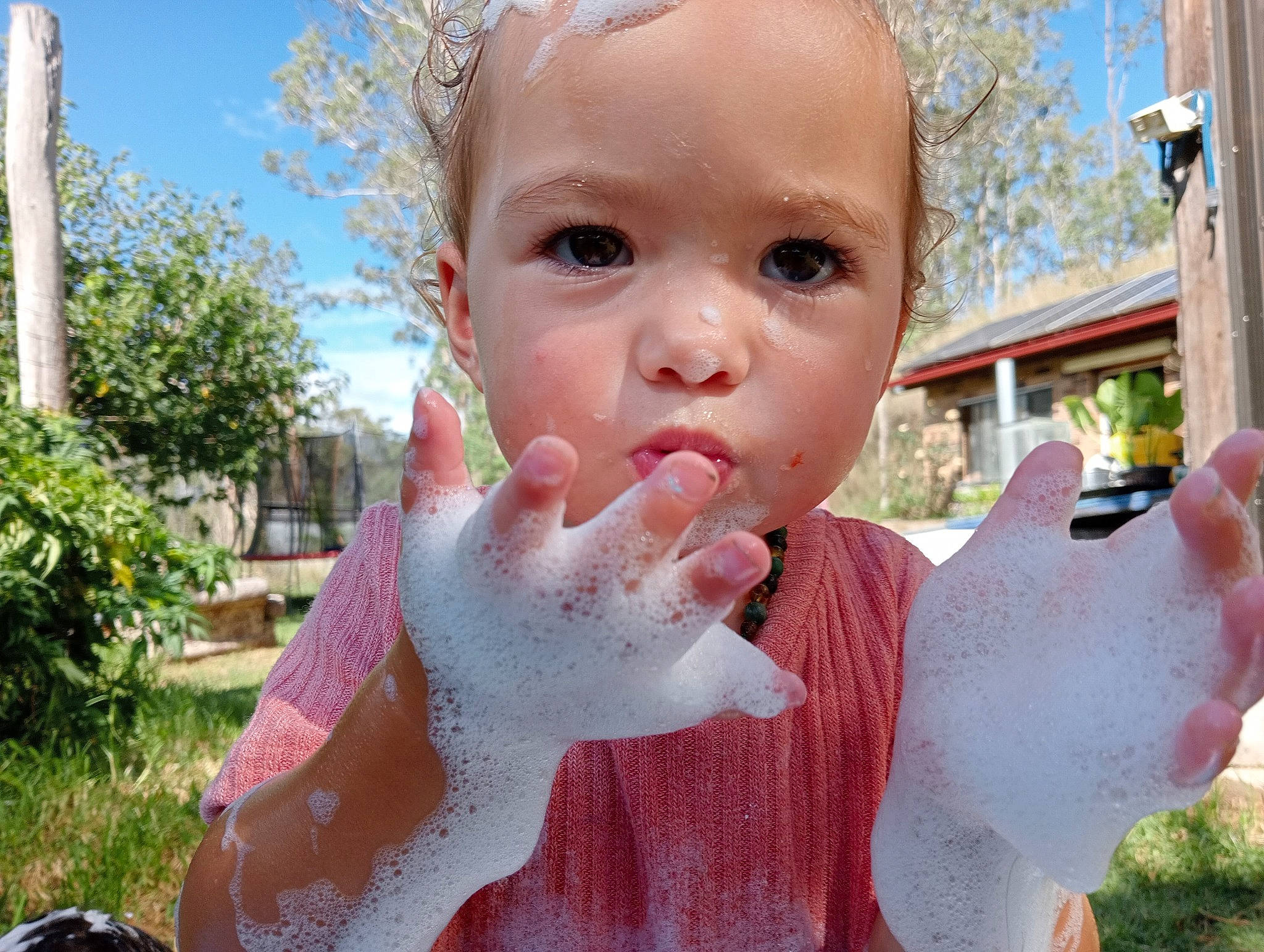Lilly-ray is registered to the contest to win money with this photo: cheek, eyelash, facial_expression, finger, fun, gesture, grass, hand, happy, head, nail, nose, person, pink, plant, skin, sky, summer, thumb, toddler