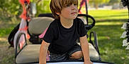 Mateo joined the competition — help win amazing prizes! child, boy, golf_cart, number, outdoor, daylight, halloween_decorations, spider_webs, orange, black, greenery, park, shorts, black_shirt, hands, face, hair, seat, steering_wheel, toy