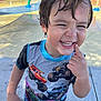 Mateo joined the competition — help win amazing prizes! child, smiling, wet_hair, splash_pad, playground, monster_truck_shirt, happy, outdoor, summer, water_play, casual_clothing, boy, concrete, sunlight, fun, cute, finger_on_mouth, short_sleeve, colorful, active