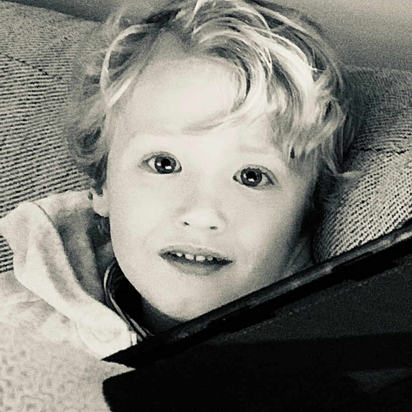 Croes Jules participe au concours pour gagner de l'argent avec cette photo : black_and_white, boy, casual, child, couch, cozy, curious, curly_hair, expression, face, hair, head, indoors, light, person, portrait, relaxed, smiling, texture, young