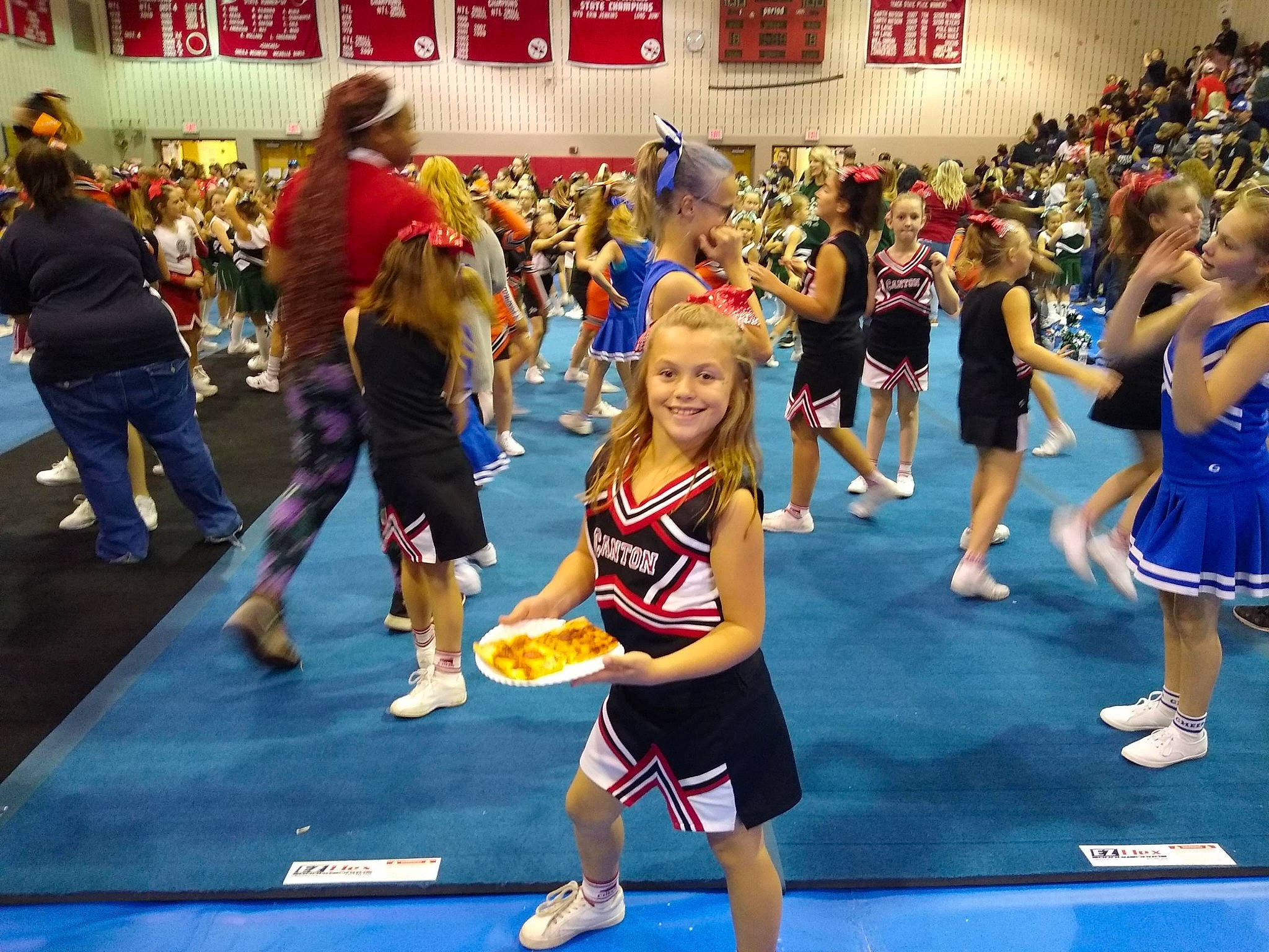 Aryana is registered to the contest to win money with this photo: championship, cheering, cheerleading, cheerleading_uniform, competition, competition_event, crowd, dance, fun, joy, leisure, performance, person, sport_venue, sports, team, team_sport, uniform