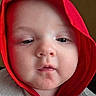 baby, child, face, hood, red_hood, close_up, portrait, skin, cheeks, eyes, nose, mouth, expression, clothing, soft_light, indoors, cute, young, infant, person