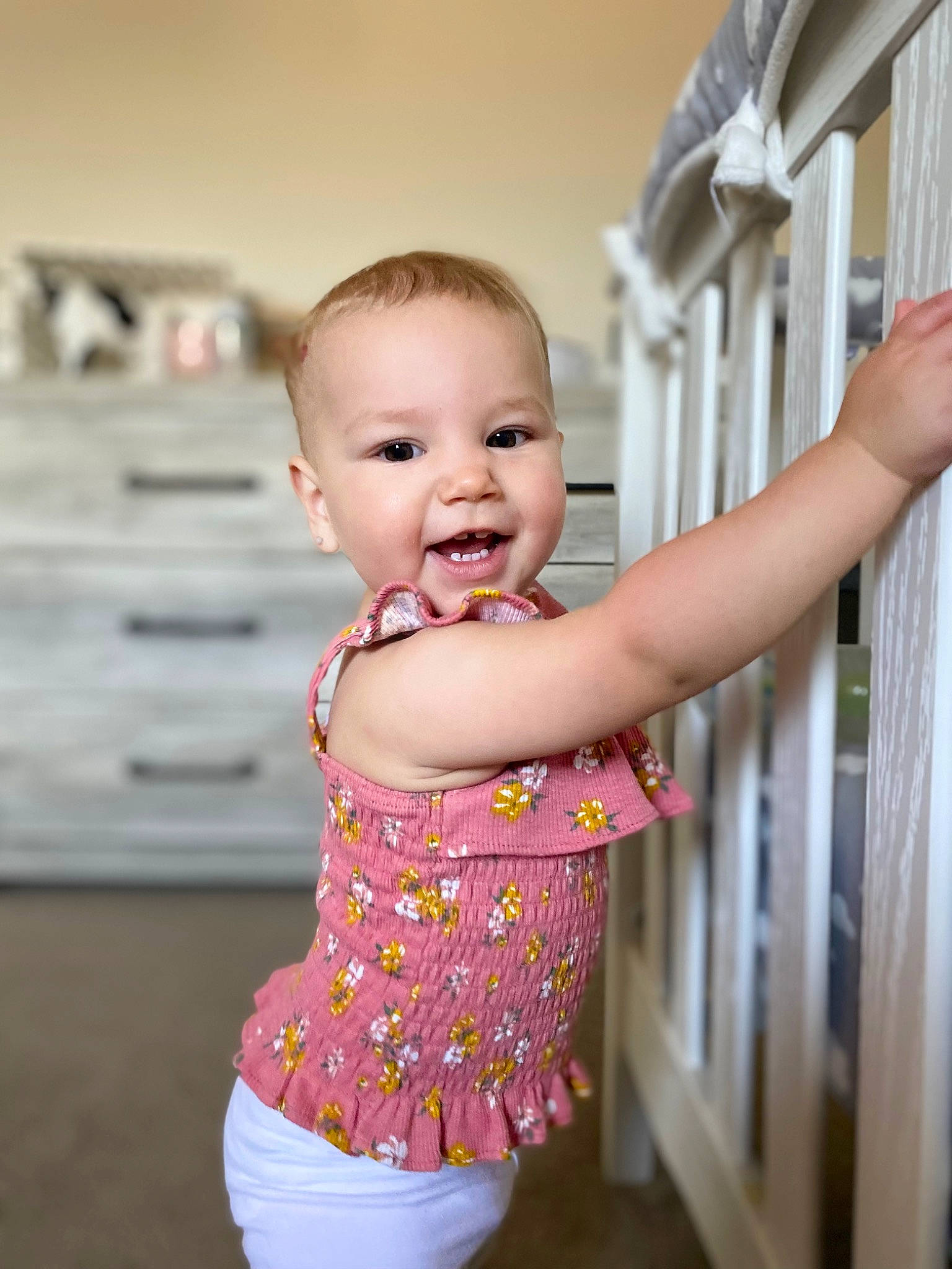 Haisley is registered to the contest to win money with this photo: arm, baby, baby_toddler_clothing, cabinetry, chest_of_drawers, child, finger, gesture, happy, iris, person, pink, product, skin, sleeve, smile, standing, thumb, toddler, waist