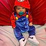 baby, child, pacifier, hood, red_clothing, blue_clothing, sneakers, nike, sitting, indoors, fabric, cute, portrait, young_child, person, footwear, colorful, soft_texture, background, hooded_outfit