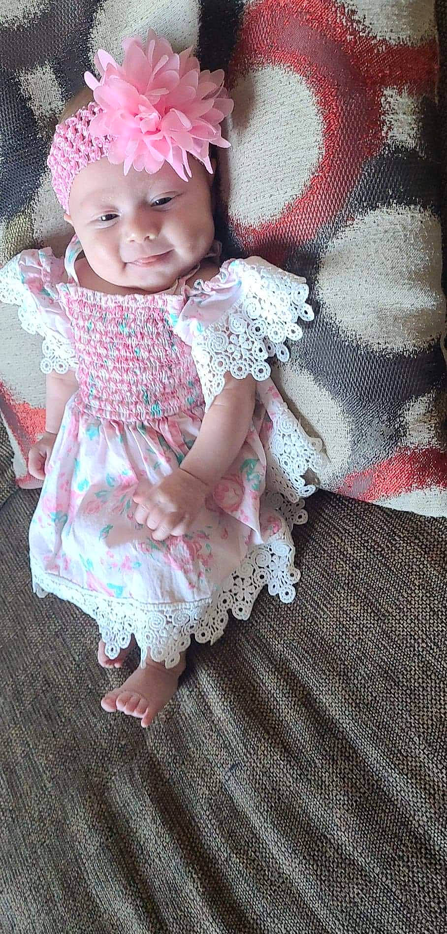 Evelyn joined the competition — help win amazing prizes! baby, baby_toddler_clothing, child, day_dress, dress, embellishment, eye, facial_expression, fashion_accessory, happy, headpiece, headwear, magenta, pattern, person, pink, ruffle, sitting, skin, sleeve