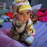 Maverick joined the competition — help win amazing prizes! baby, bed, blanket, child, clothing, colorful, cozy, cute, expression, face, hat, indoors, infant, looking, nursery, person, pillow, sitting, soft, young