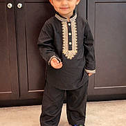Ekamjot is registered to the contest to win money with this photo: black_outfit, cabinet, carpet, child, cute, floor, golden_embroidery, happy, headwear, home_interior, indoor, looking_at_camera, person, portrait, small_person, smiling, standing, traditional_clothing, turban, young_child