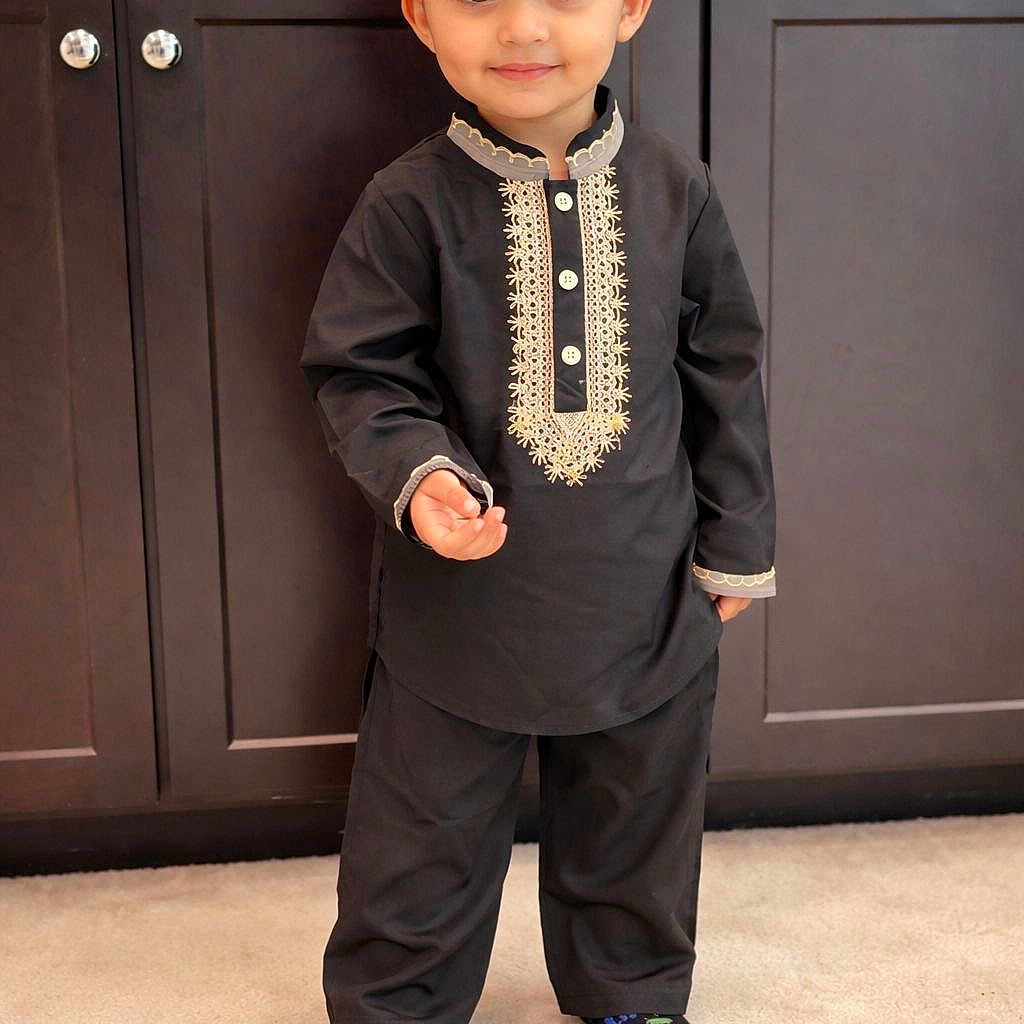 Ekamjot is registered to the contest to win money with this photo: black_outfit, cabinet, carpet, child, cute, floor, golden_embroidery, happy, headwear, home_interior, indoor, looking_at_camera, person, portrait, small_person, smiling, standing, traditional_clothing, turban, young_child