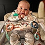 Kash Parsons is registered to the contest to win money with this photo: baby, infant, smile, happy, face, child, sitting, clothing, onesie, toy, baby_seat, colorful, patterned, comfort, cute, indoor, portrait, closeup, hand, expression