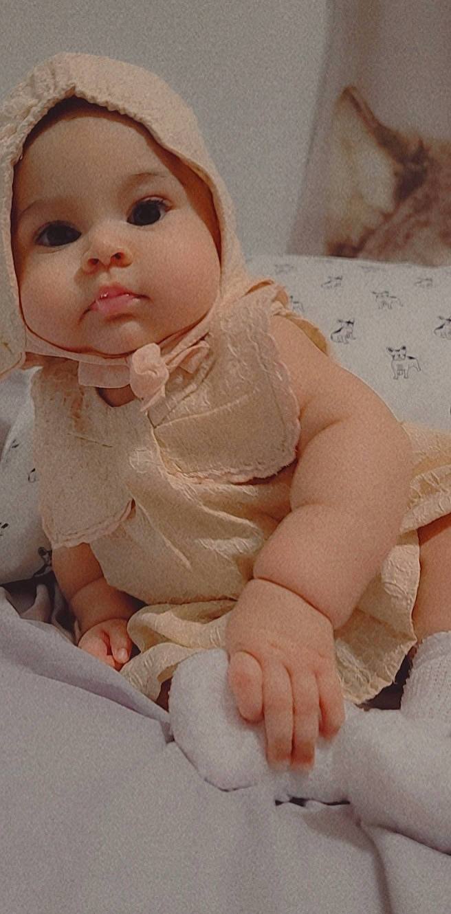 Kira is registered to the contest to win money with this photo: baby, baby_toddler_clothing, cheek, child, comfort, doll, dress, eyelash, finger, iris, linens, lip, neck, peach, person, pink, skin, sleeve, textile, toddler