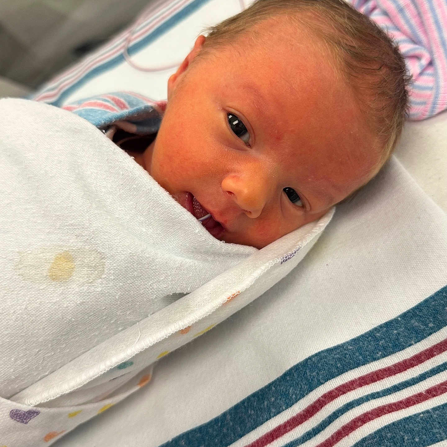 Justin is registered to the contest to win money with this photo: baby, bed, blanket, cozy, cute, eyes, face, fresh, head, hospital, infant, lying_down, newborn, person, portrait, skin, sleepy, striped_sheet, swaddled, wrapped