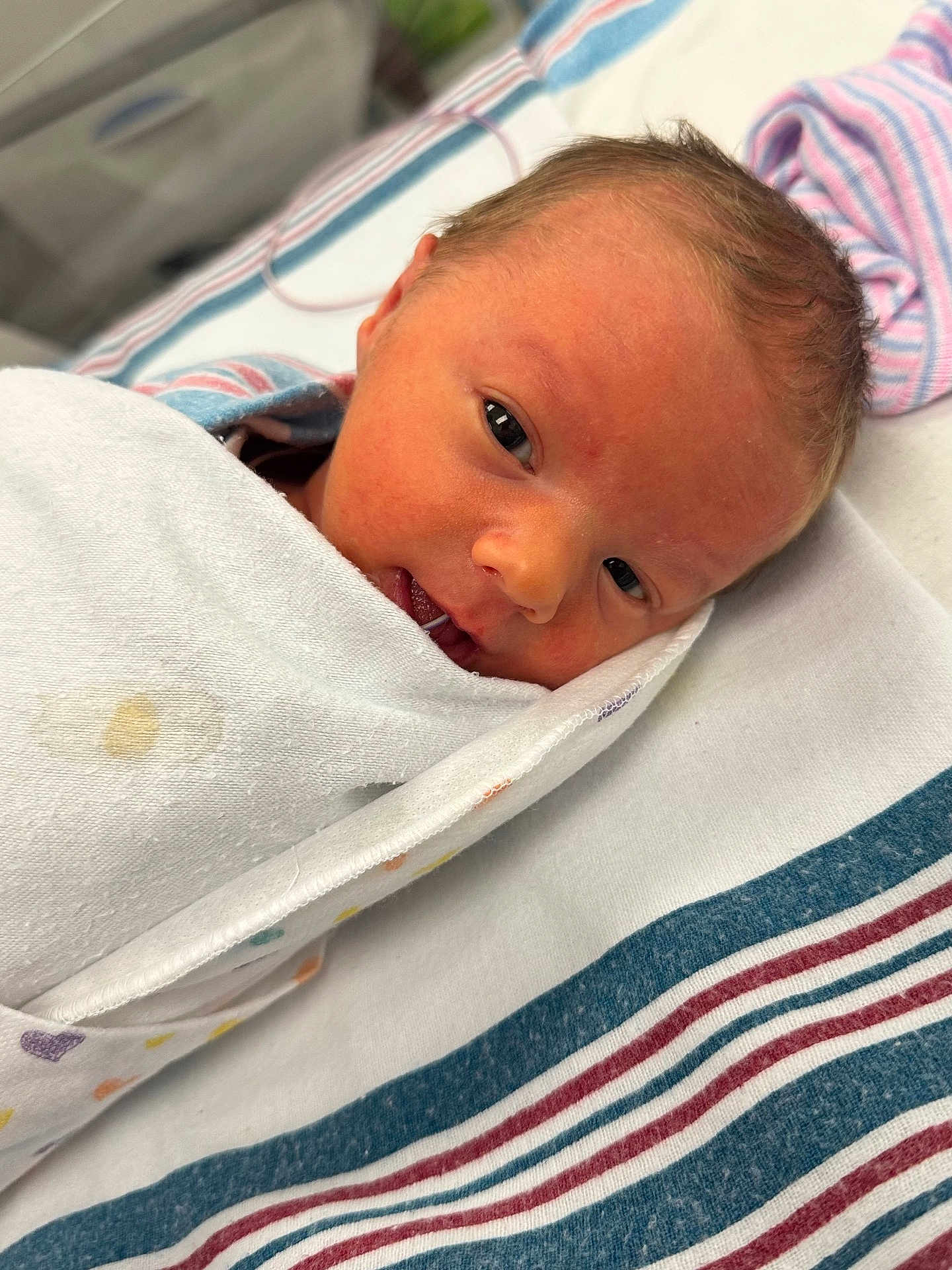 Justin is registered to the contest to win money with this photo: newborn, baby, infant, swaddled, blanket, face, hospital, bed, striped_sheet, lying_down, cute, fresh, skin, eyes, head, person, portrait, wrapped, cozy, sleepy