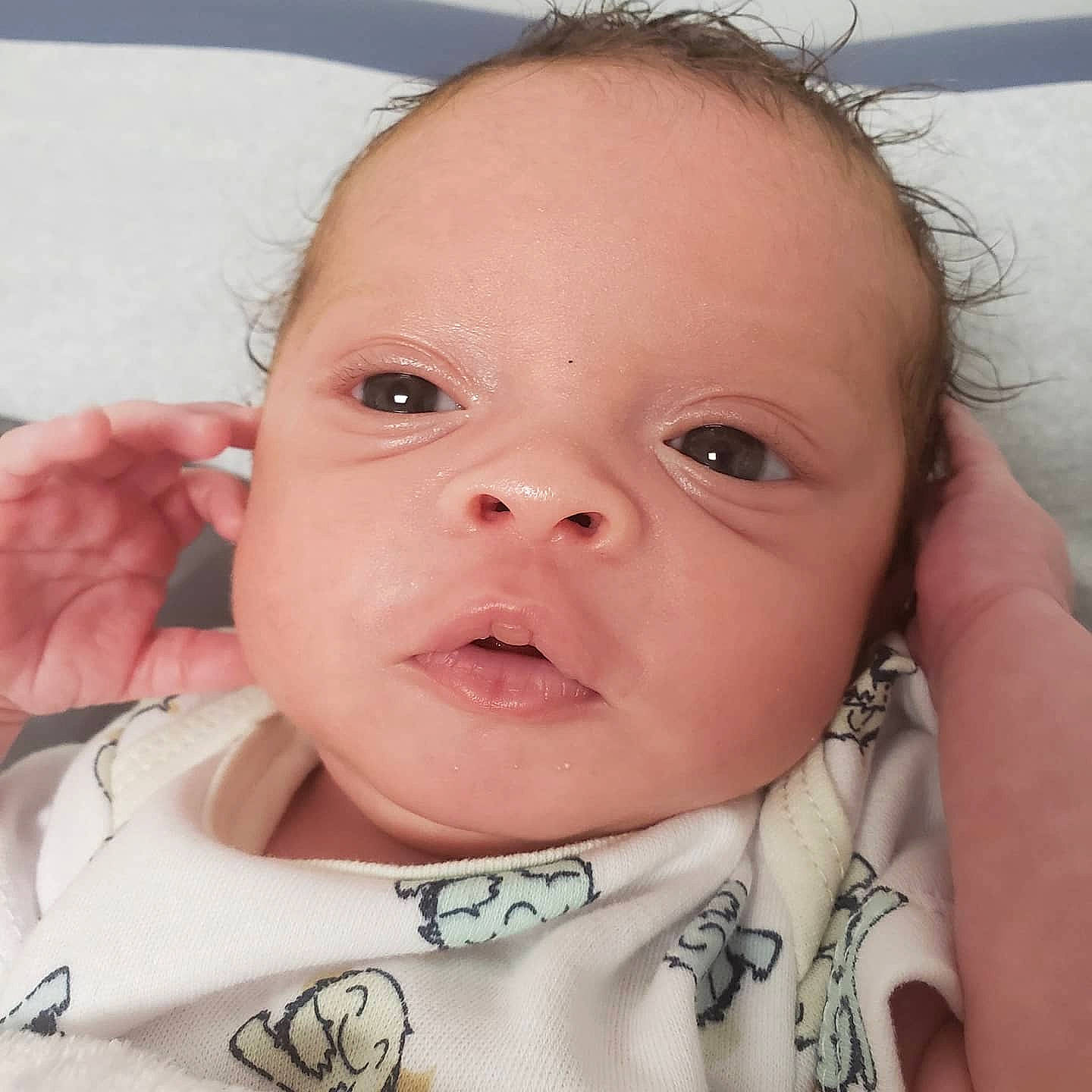 Joziah is registered to the contest to win money with this photo: baby, baby_toddler_clothing, cheek, child, comfort, ear, eyebrow, eyelash, face, happy, head, iris, lip, mouth, neck, nose, person, skin, thumb, toddler