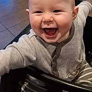 Kensen is registered to the contest to win money with this photo: baby, babylaughing, bodypart, chair, clothing, coat, face, furniture, happy, head, hosiery, laughing, mouth, pants, person, photography, portrait, smile, sock, teeth