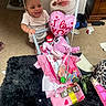 Iyanna is registered to the contest to win money with this photo: baby, balloon, basket, carpet, child, clothing, container, floor, furniture, gift, happy, heart, indoor, person, pink, room, rug, smile, stuffed_animal, toy