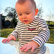 Elyo a rejoint le concours — aidez-le/la à gagner de superbes lots ! child, baby, toddler, face, hands, reflection, glass_table, striped_shirt, bonjour_text, heart_emoji, outdoor, garden, trees, blue_sky, sunlight, portrait, curiosity, cute, long_sleeves, closeup