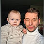 Elyo participe au concours pour gagner de l'argent avec cette photo : baby, man, child, parent, selfie, portrait, indoor, blue_eyes, beard, turtleneck, button_up_shirt, holding, close_up, family, skin, hair, living_room, lamp, neutral_expression, gaze